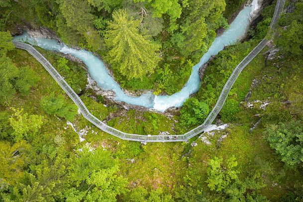 Drohnenaufnahme Geisterklamm - Vogelperspektive Steg entlang des Flusses mit zwei Personen