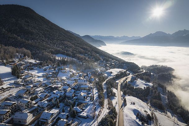 Drohnenaufnahme Reith bei Mittagslicht mit Nebel im Inntal
