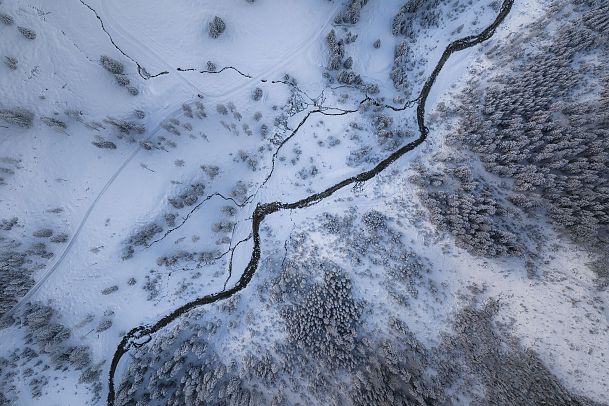 Gaistal Natur im Winter - Drohnenaufnahme Flusslauf aus der Vogelperspektive quer durch das Bild