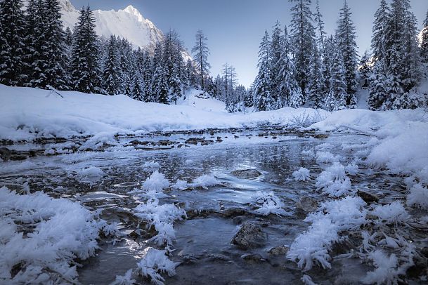 Gaistal Natur im Winter - gefrorener Flusslauf mit beschneiten Bäumen und Hohe Wand