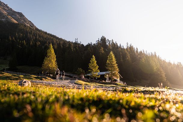 Gaistalalm beim Sonnenaufgang mit blauem Himmel (mit Radfahrerinnen)