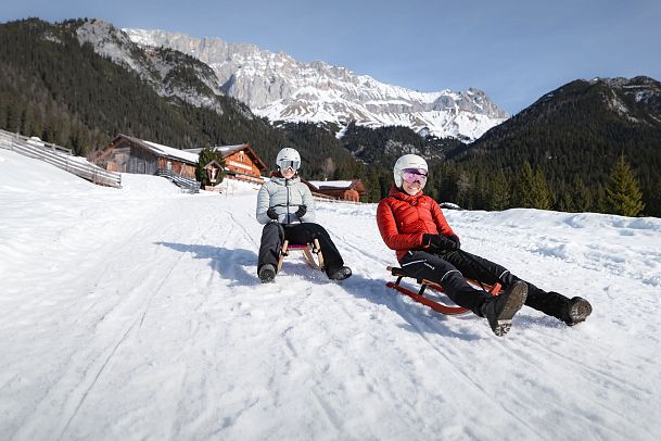 Rodeln im Gaistal_zwei Frauen auf der Abfahrt vor der Hämmermoosalm