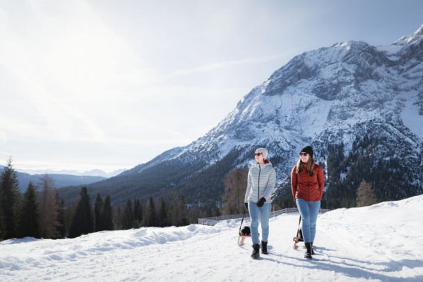 Rodeln im Gaistal_zwei Frauen laufen hinauf zur Hämmermoosalm