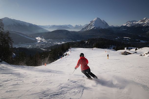 Skifahrerin an der Rosshütte - Skifahrerin am carven mit Blick Richtung Hohe Munde