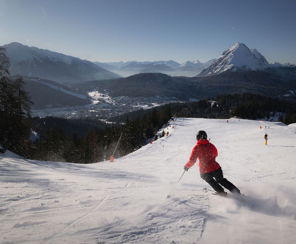 Skifahrerin an der Rosshütte - Skifahrerin am carven mit Blick Richtung Hohe Munde