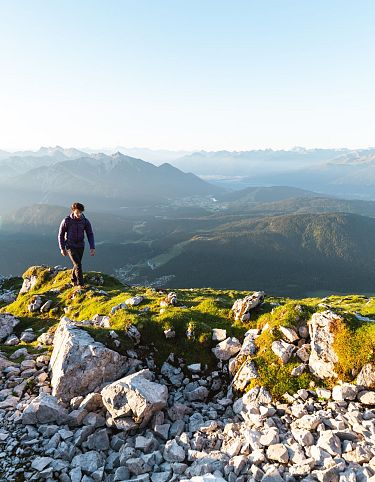 Wanderer auf der Gehrenspitze im Sonnenaufgang - Blick auf die Region Seefeld