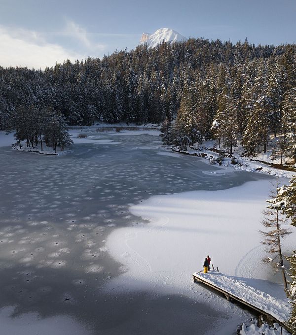 Winterwandern Paar Möserer See Drohnenaufnahme Paar steht am Steg Blick Richtung Huhe Munde